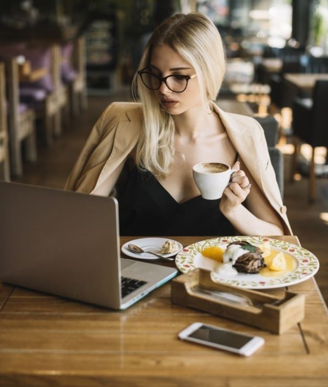 Девушка за ноутбуком в кафе